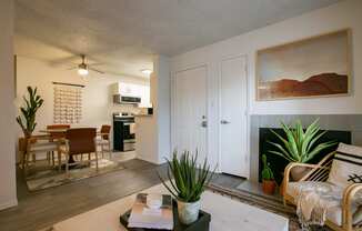 a living room with a fireplace and a dining room in the background