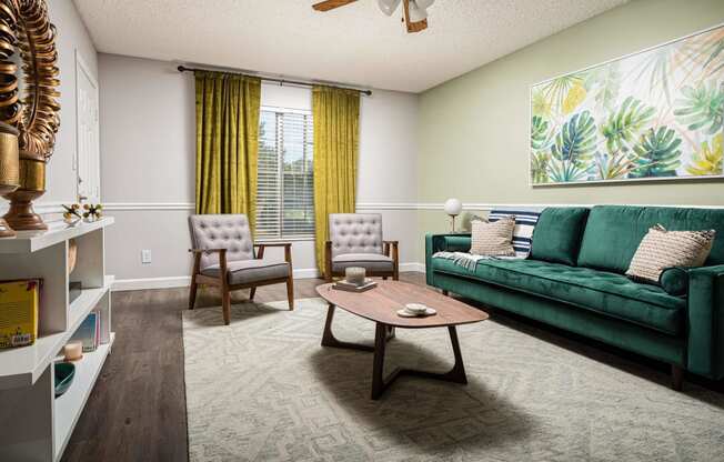 a living room with a green couch and a coffee table  at The Park at Chesterfield Apartment Homes, Tampa, Florida