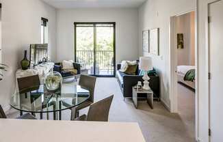 A modern living room with a glass table and chairs.