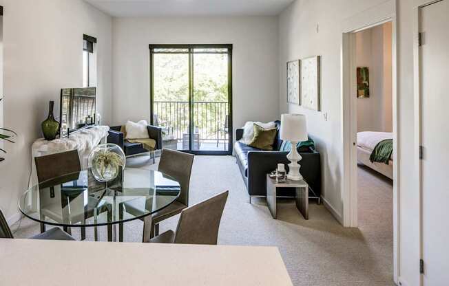 A modern living room with a glass table and chairs.