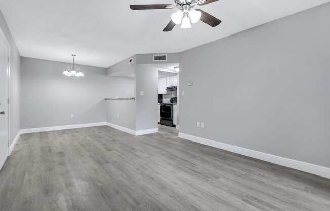 the living room of an empty house with a ceiling fan