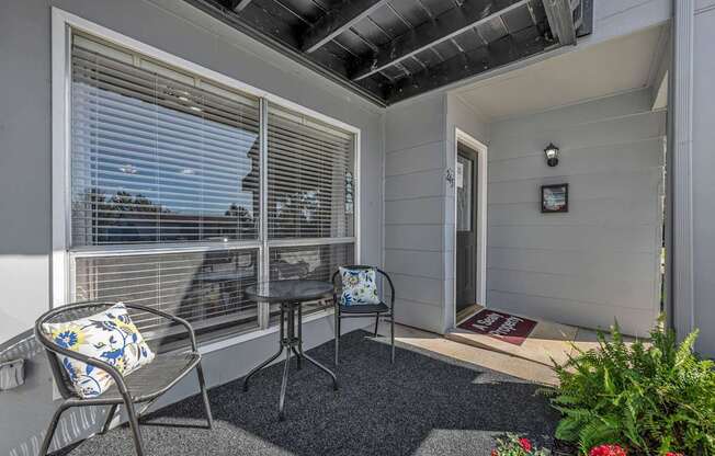 A balcony with a chair and table.