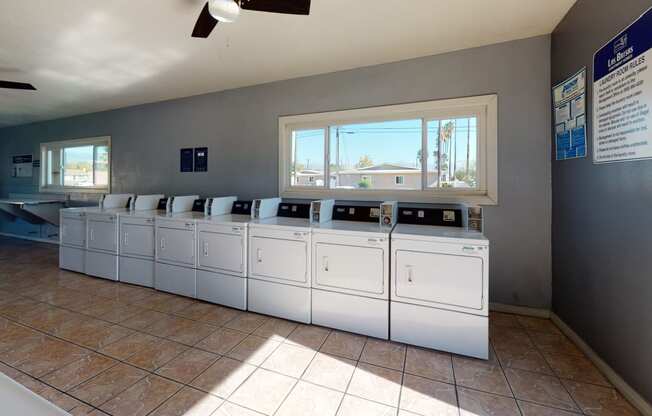 Colton CA Apartments - Las Brisas Apartments Laundry Room with Washers, Dryers, and Folding Station
