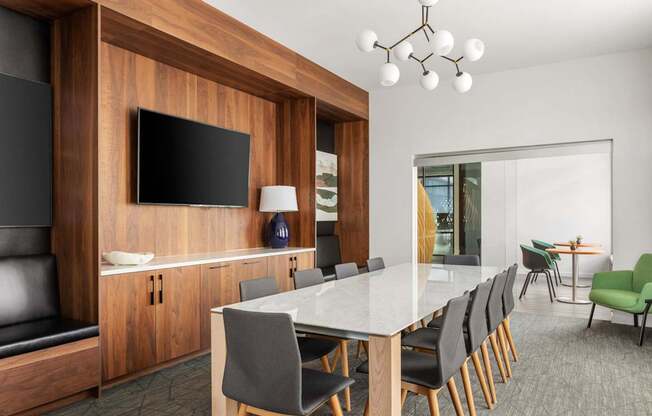 A modern dining room with a long table and chairs.