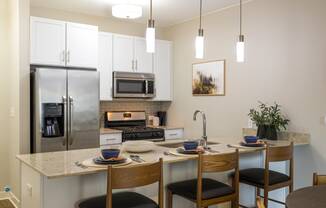 a kitchen with a large island with a breakfast bar and stainless steel appliances