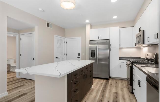 a renovated kitchen with white cabinets and stainless steel appliances