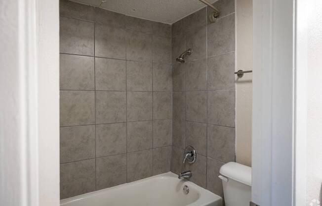 A bathroom with a white tub and toilet.