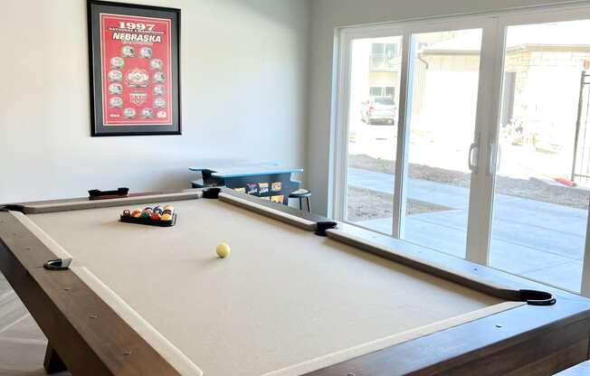 a pool table in a game room with a view of the patio