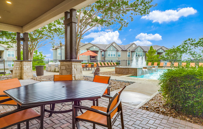 a patio with a table and chairs and a fountain