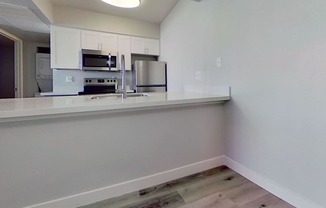 A kitchen with white cabinets and appliances.
