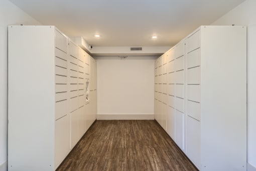 a room with white lockers and a wood floor