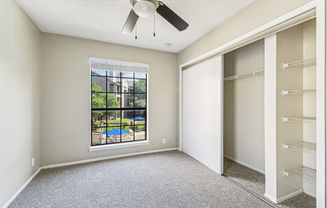 Bright bedroom with a big window at Bandera Crossing apartments in San Antonio, TX