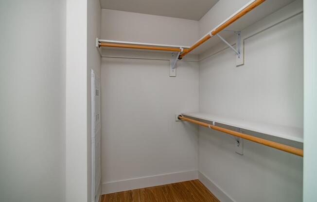 A white room with a shelf and a door.