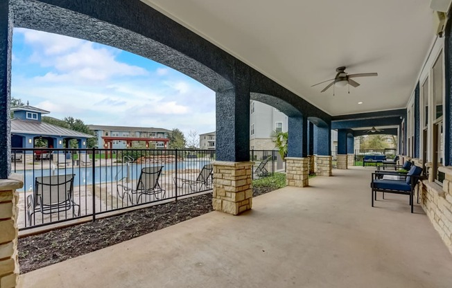 A patio with a pool and a black metal fence.