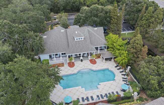 A house with a pool surrounded by trees.