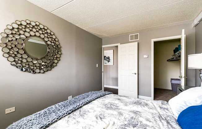 A bedroom with a bed and a mirror on the wall.