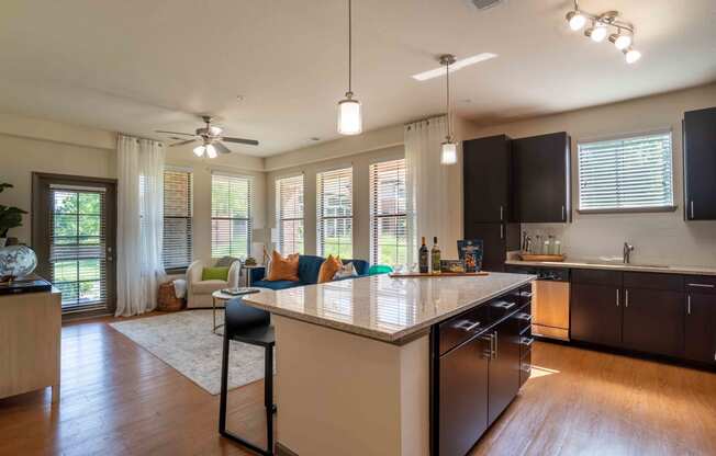 an open kitchen and living room with a large counter top