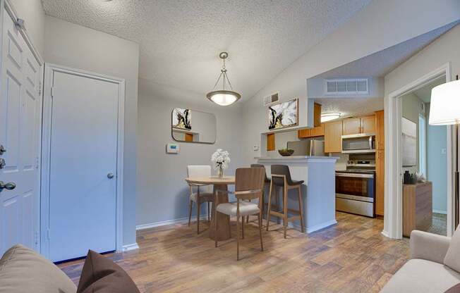 A kitchen with a dining table and chairs.