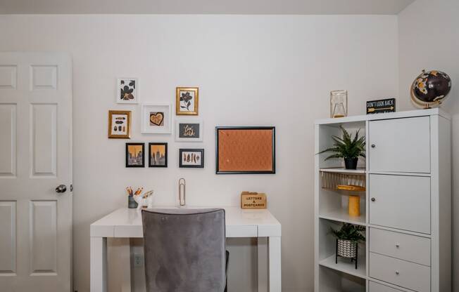 a home office with a white desk and a grey chair