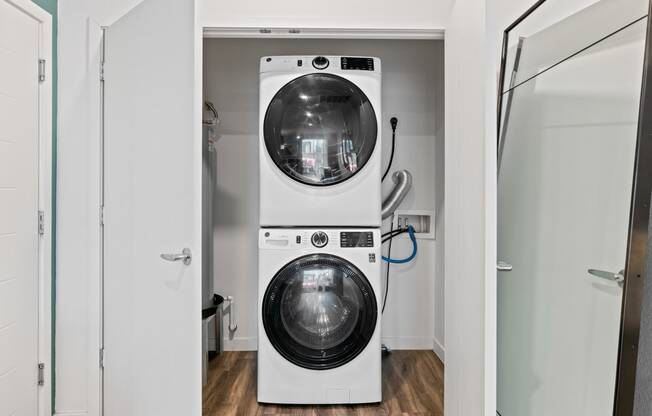 a white washer and dryer in a white laundry room