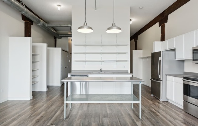 a kitchen with white cabinets and stainless steel appliancesat Gaar Scott Historic Lofts, Minneapolis