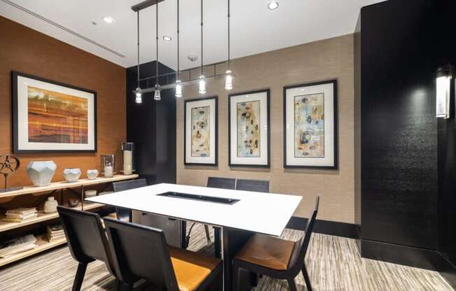 A modern dining room with a white table and black chairs.