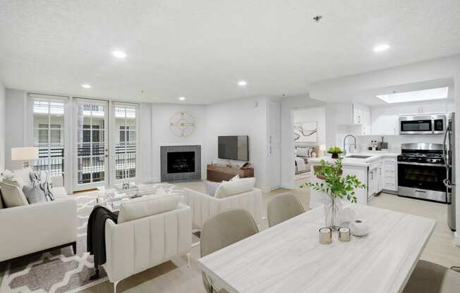 a living room and dining room with white furniture and a table