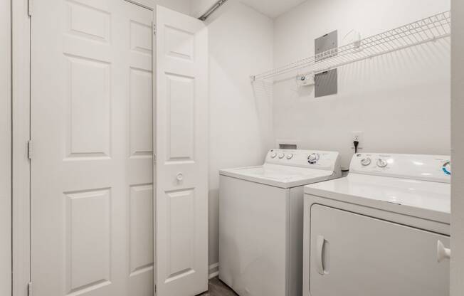 a white washer and dryer in a white laundry room with white doors