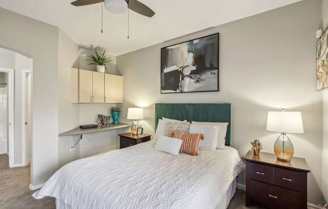 A bedroom with a large bed and a ceiling fan.