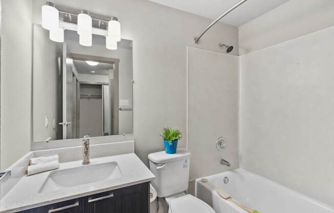 A white bathroom with a sink, toilet, and bathtub.