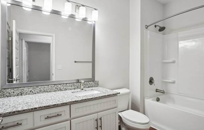 A white bathroom with a sink, toilet, and bathtub.