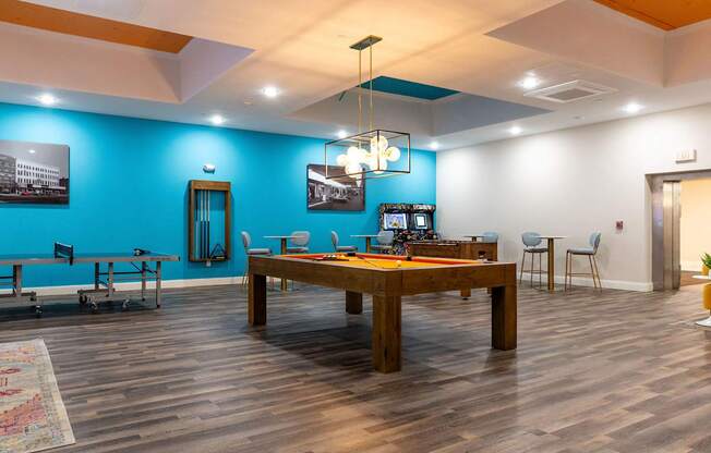 a large pool table in a room with a blue accent wall and a game room