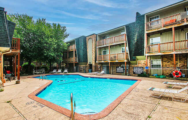 a resort style pool is in the middle of an apartment building