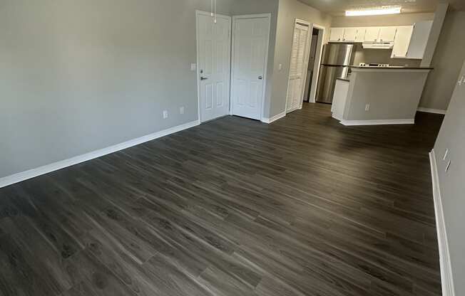 an empty living room with a ceiling fan