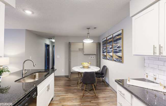 a kitchen and dining room with white cabinets and a table and chairs