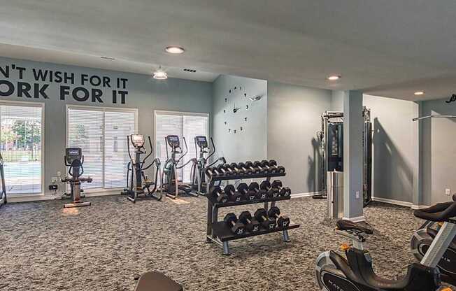 A gym with a variety of equipment including treadmills, weights, and exercise bikes.