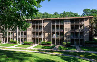 A large apartment complex with a green lawn in front.