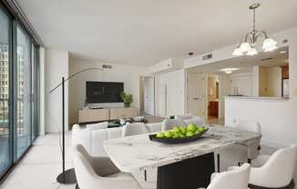 a living room and dining room with white chairs and a marble table