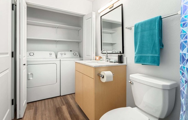 a bathroom with a toilet and a sink and a washing machine