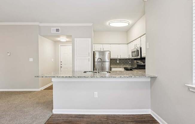 A kitchen with a white countertop and a sink.