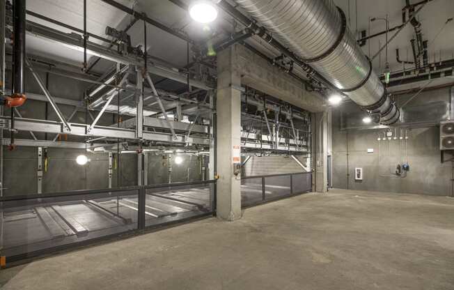 a large empty room in a building with a large pipe running up the side of the room