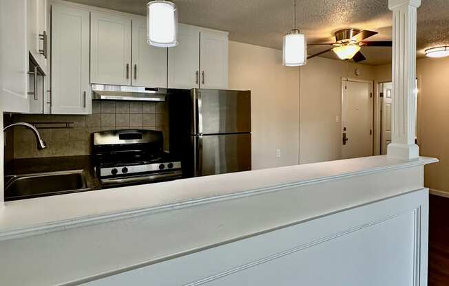 a view of a kitchen from behind a bar with two lights