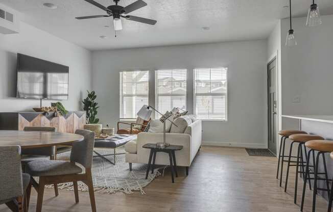 a living and dining area with a ceiling fan and hardwood floors