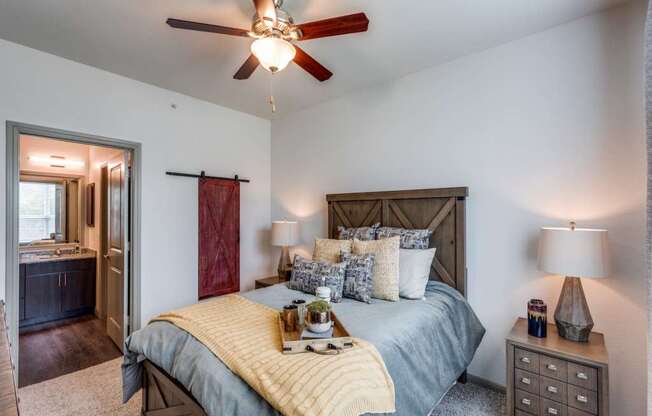 A bedroom with a bed, nightstand, and a ceiling fan.