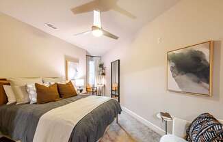 A bedroom with a large bed and a ceiling fan.