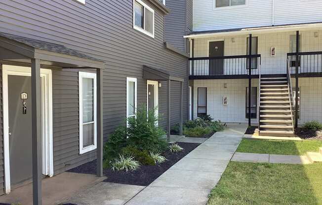 a side view of a house with a sidewalk in front of it