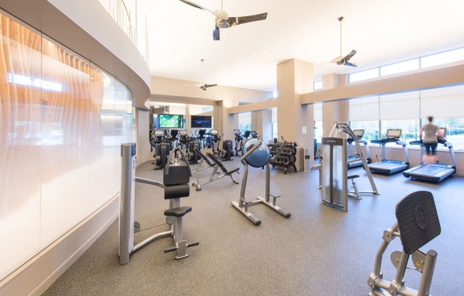 a large fitness room with treadmills and other exercise equipment at The Acadia at Metropolitan Park, Arlington