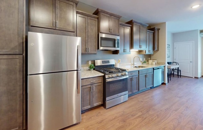a kitchen with stainless steel appliances and wooden floors