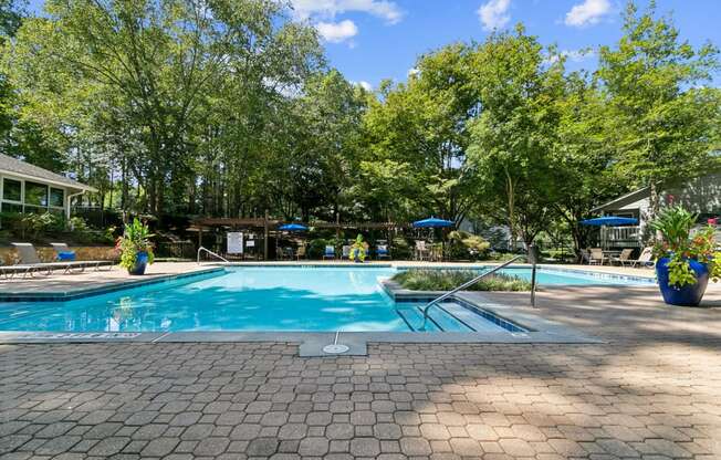 a swimming pool with trees in the background