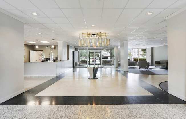 A large, open space with a black and white checkered floor and a chandelier hanging from the ceiling.